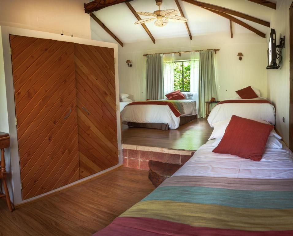 A bedroom with two beds and a wooden door