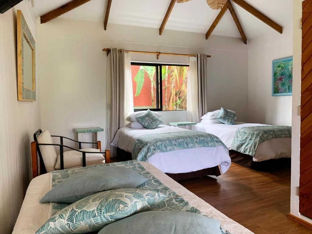 A bedroom with two beds , a chair and a window.