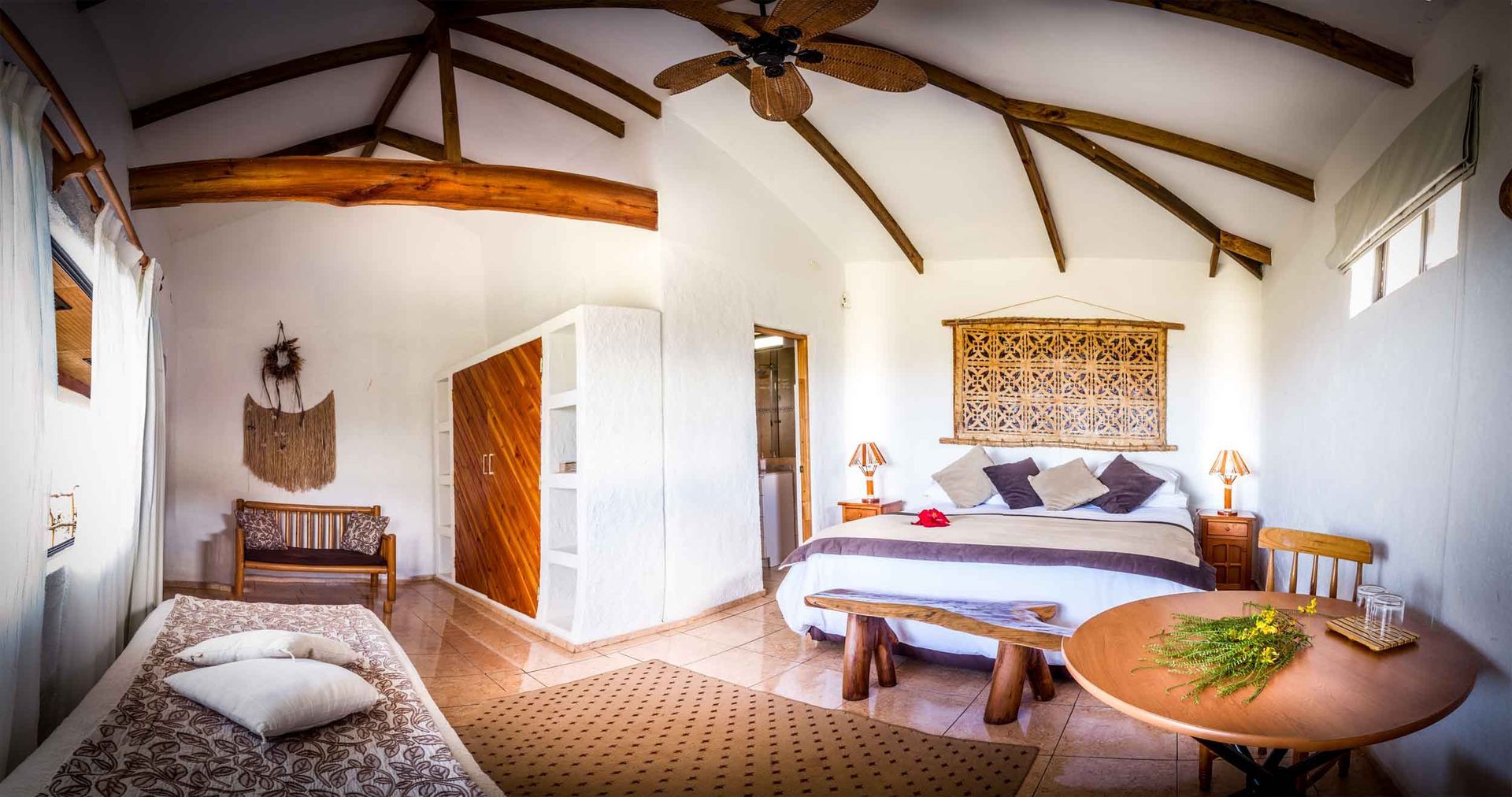 A bedroom with three beds and a painting on the wall