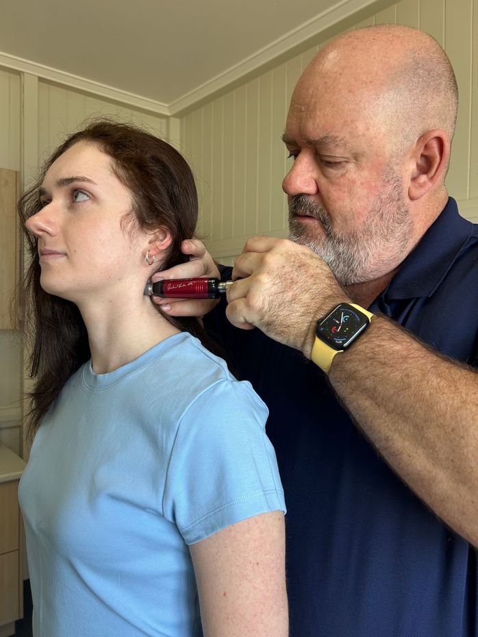 Woman Examining Another Woman's Neck in a Clinical Setting — Wide Bay Chiropractic in Gympie, QLD