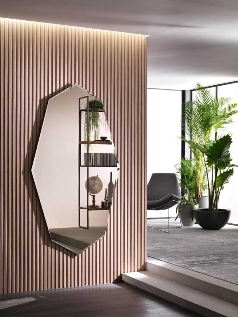 Specchio geometrico con mensole integrate, montato su una parete verticale con doghe in legno.
