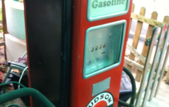 Pompa di benzina Hudson vintage rossa e nera con indicatore visibile, all'aperto.