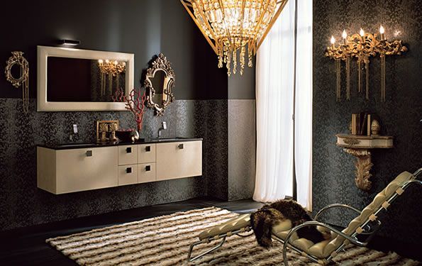 Lussuoso bagno con pareti scure, dettagli dorati, mobile lavabo sospeso e lampadario.
