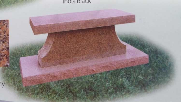 Pink stone bench on grass with a curved pedestal base