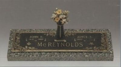 Floral grave marker with the name McReynolds engraved on a dark plaque.