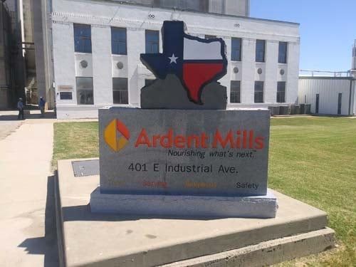 Ardent Mills sign in front of a white industrial building with a Texas-shaped logo