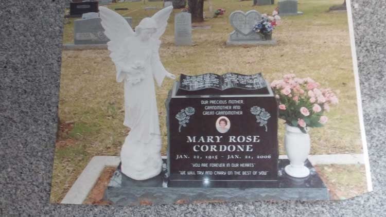 Gravestone with white angel statue and pink flowers in a cemetery, for Mary Rose Cordone.