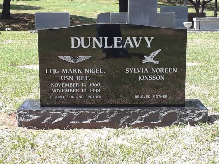 Black granite Dunleavy memorial headstone in a cemetery, with engraved names and dates.