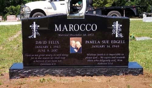 Black granite memorial headstone engraved “MAROCCO” in a grassy cemetery, with white truck in background