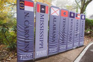 A row of flags with the names of the seven states on them