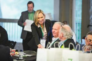 A woman is talking to a group of people at a conference.