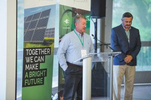 Two men are standing in front of a podium with a sign that says `` together we can make a bright future ''.
