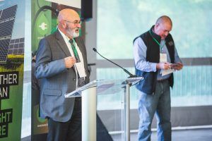 Two men are standing at a podium giving a speech.