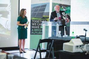 A man and a woman are standing in front of a podium giving a presentation.