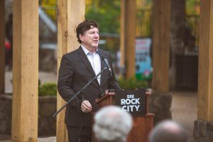 A man in a suit is standing at a podium giving a speech.