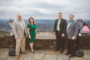 A group of people standing next to each other on top of a hill.
