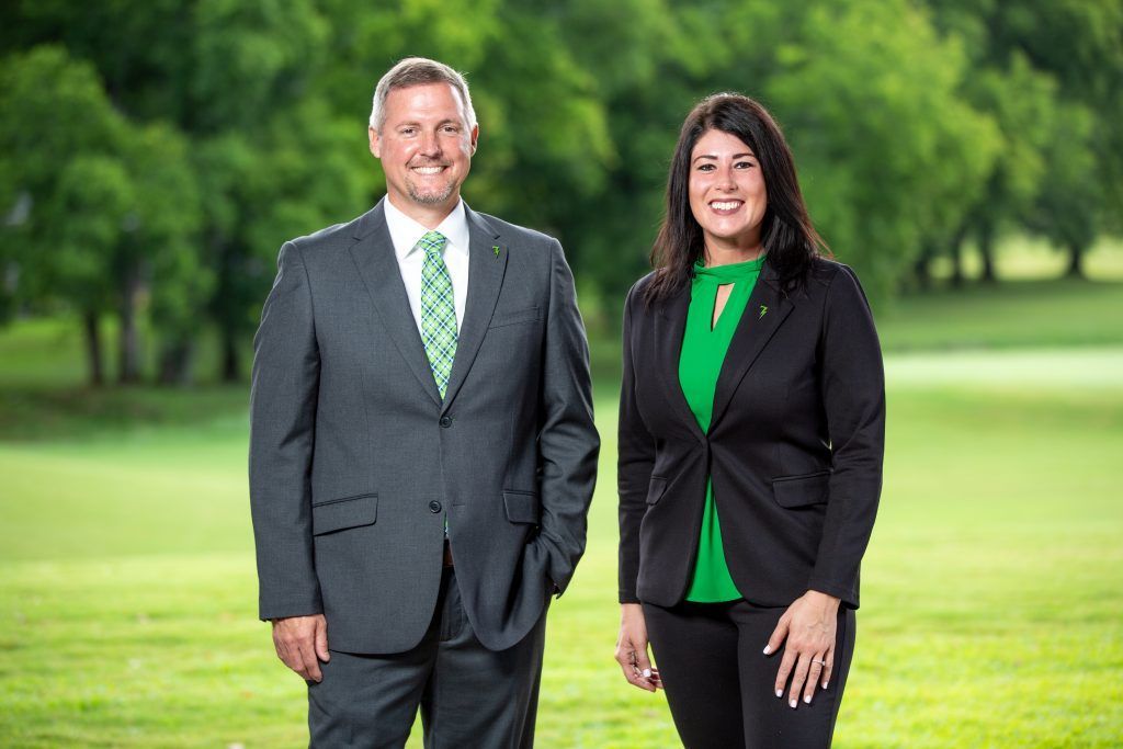 A man and a woman are standing next to each other in a field.