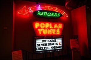 A neon sign that says poplar tunes welcome seven states and endless highway