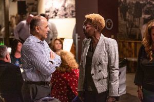 A man and a woman are talking to each other in a crowded room.