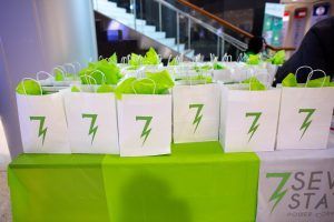 A table topped with a row of white bags with green lightning bolts on them.