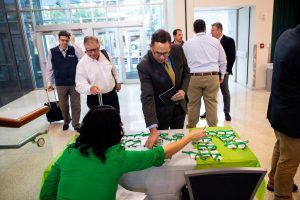 A group of people are standing around a table with cards on it.