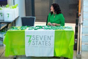 A woman is sitting at a table with a green table cloth.