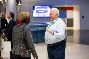 A man and a woman are talking to each other in a lobby.