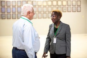 A man and a woman are standing next to each other and talking.