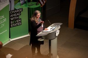 A woman is standing at a podium giving a speech.