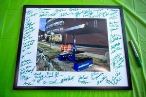 A framed picture with signatures on it is sitting on a table.