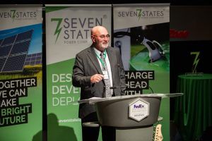 A man in a suit and tie is standing at a podium giving a speech.