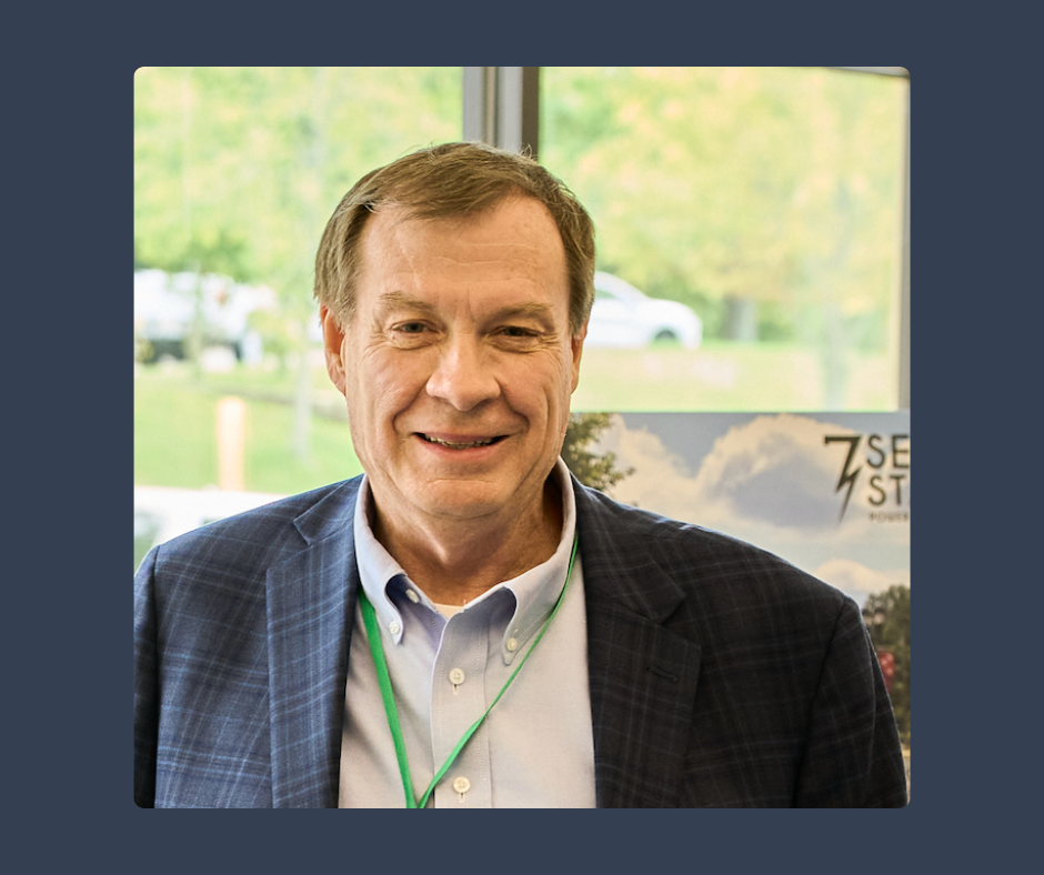 A man in a suit with a green lanyard around his neck
