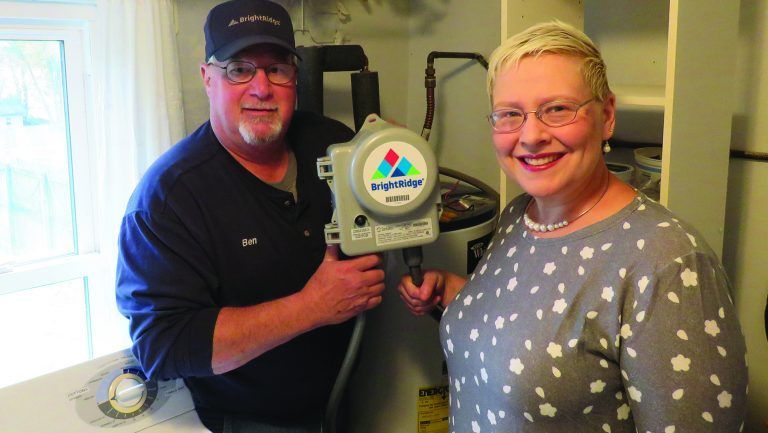 A man and a woman are standing next to each other holding a machine.