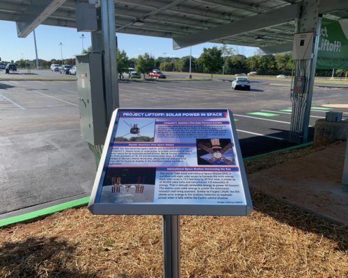 A sign in a parking lot explains how solar panels work