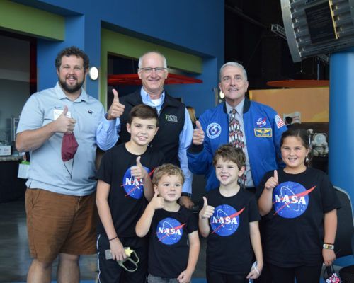 A group of people wearing nasa shirts are posing for a picture.