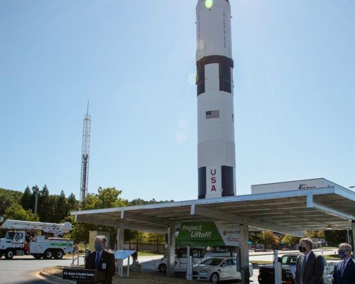 A man stands in front of a rocket that says usa on it