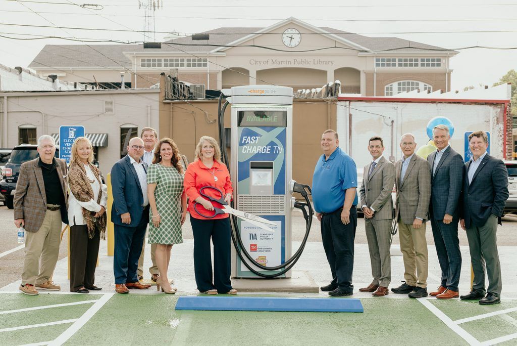 A group of people are standing in front of a gas pump.