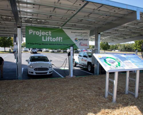 A car is charging under a sign that says project liftoff