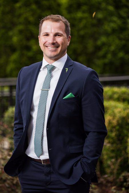 A man in a suit and tie is standing with his hands in his pockets.