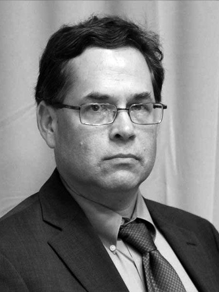 A man in a suit and tie is wearing glasses