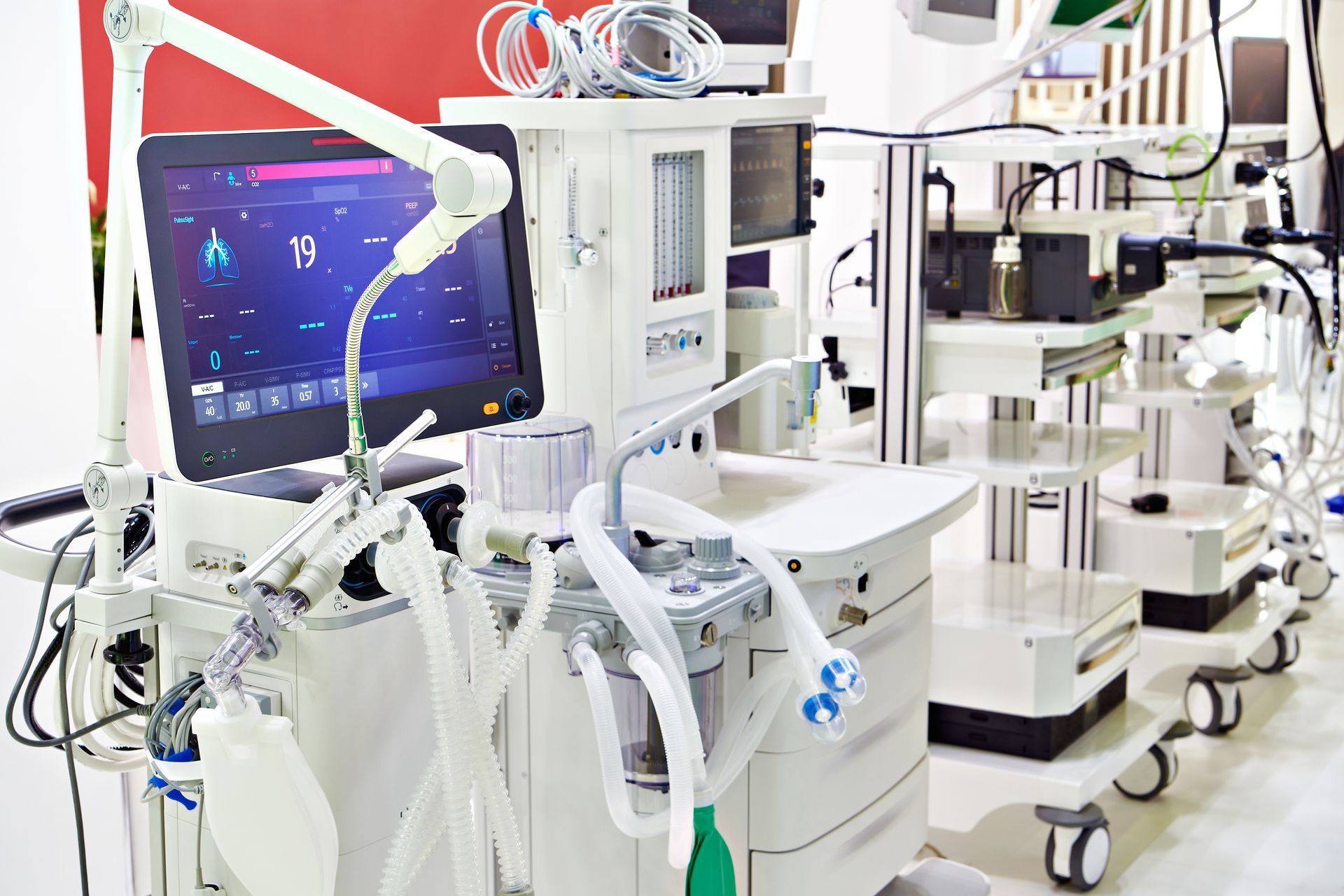 Modern hospital room equipped with advanced medical monitors and ventilators.