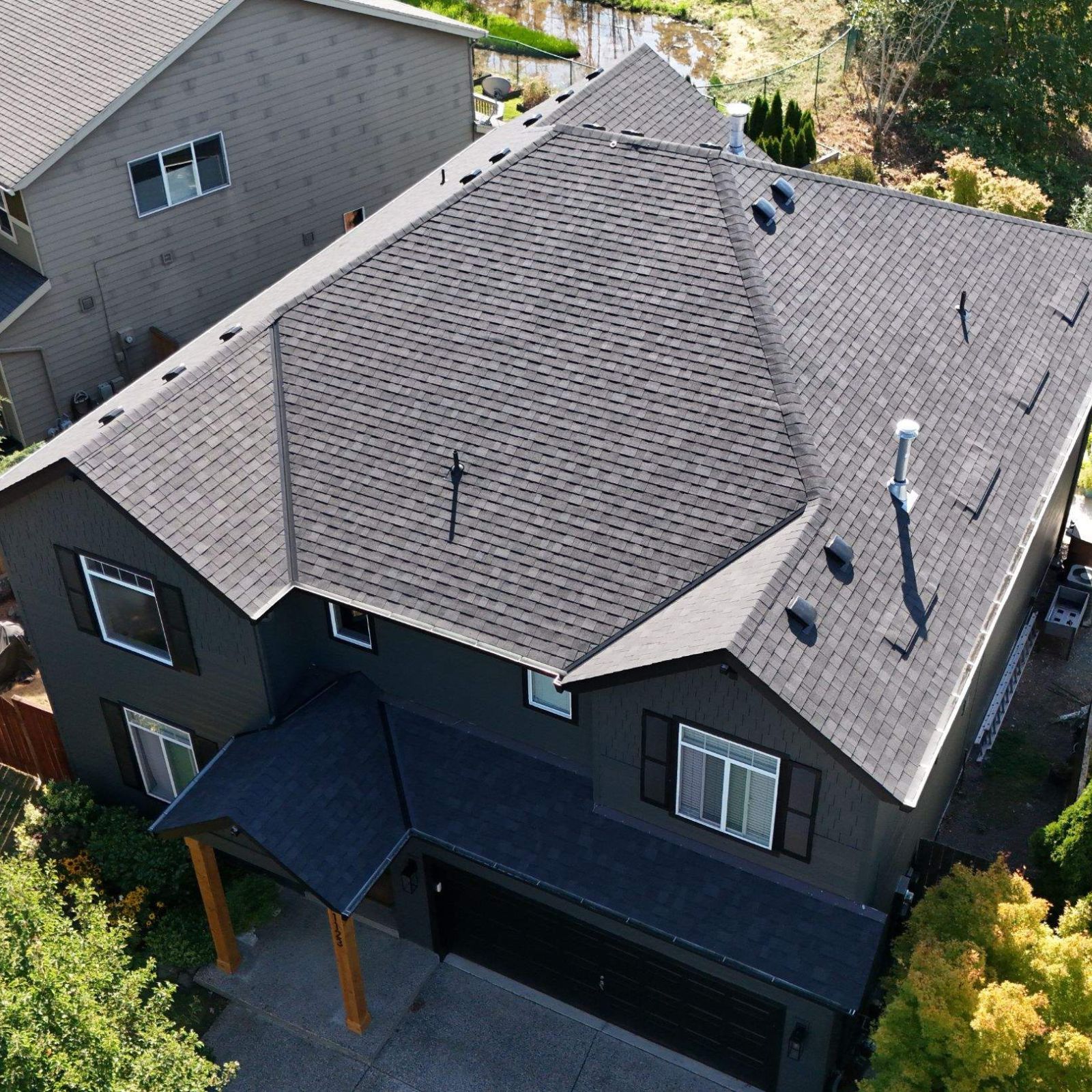 Best Time to Replace a Roof in Heisson, WA
A Valiant Roofing crew installs new architectural shingles on a Heisson home beneath a clear summer sky, the river valley stretching out behind the rooftop. One installer kneels along the ridge securing cap shingles while another carries a bundle up the ladder, rolls of synthetic underlayment staged along the eave. The afternoon sun warms the shingles enough for proper sealing, the kind of dry, mild window that defines peak roofing season in Clark County from late spring through early fall. The scene shows why scheduling now gives homeowners the longest dry stretches and the cleanest install. Visit Valiant Roofing at 108 SE 124th Ave Suite 8, Vancouver, WA 98684 or https://www.valiantroofing.com/locations/vancouver-wa