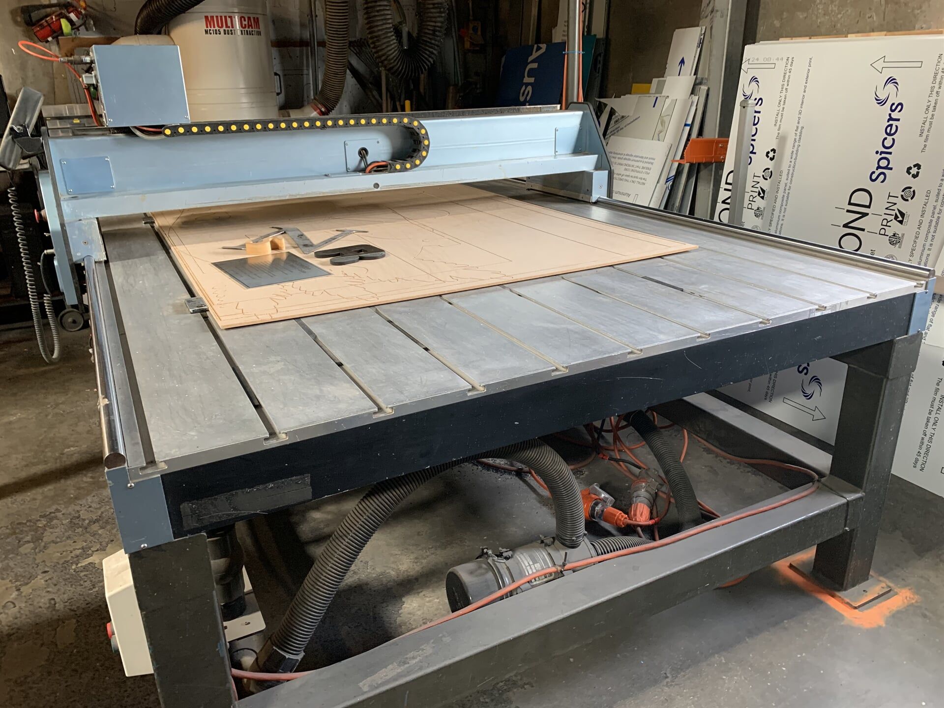 A Machine Is Cutting A Piece Of Wood On A Table — Cairns Signcorp In Portsmith, QLD