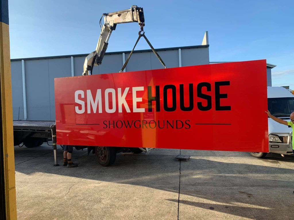 A Red Sign That Says Smokehouse Is Being Lifted By A Crane — Cairns Signcorp In Portsmith, QLD