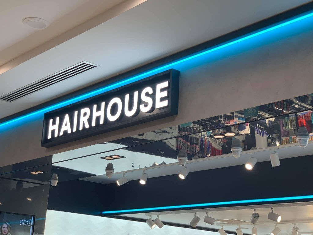 A Sign For Hairhouse Is Hanging From The Ceiling Of A Store — Cairns Signcorp In Portsmith, QLD