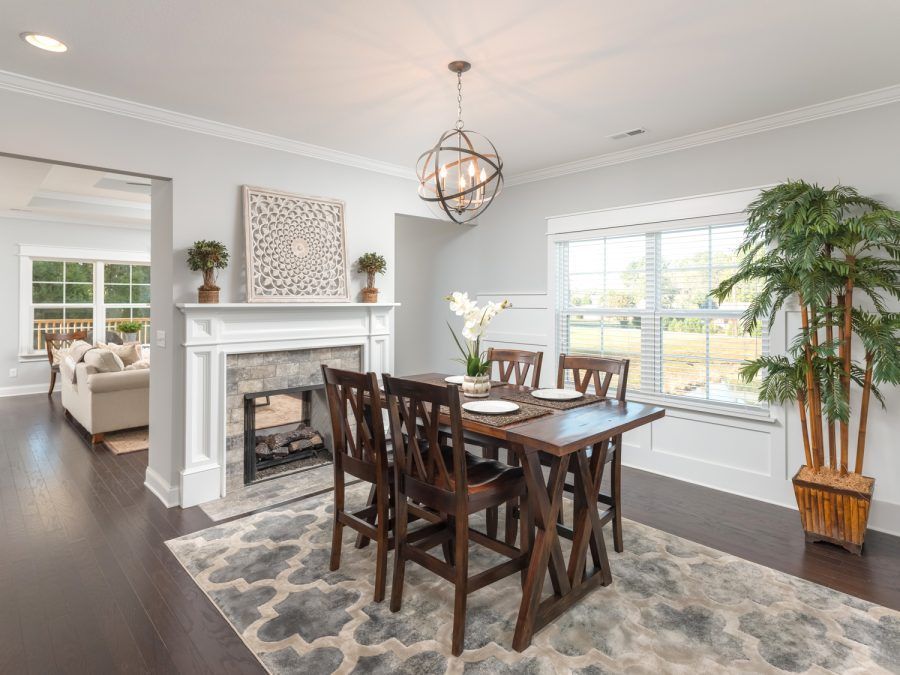 A dining room with a table and chairs and a fireplace.