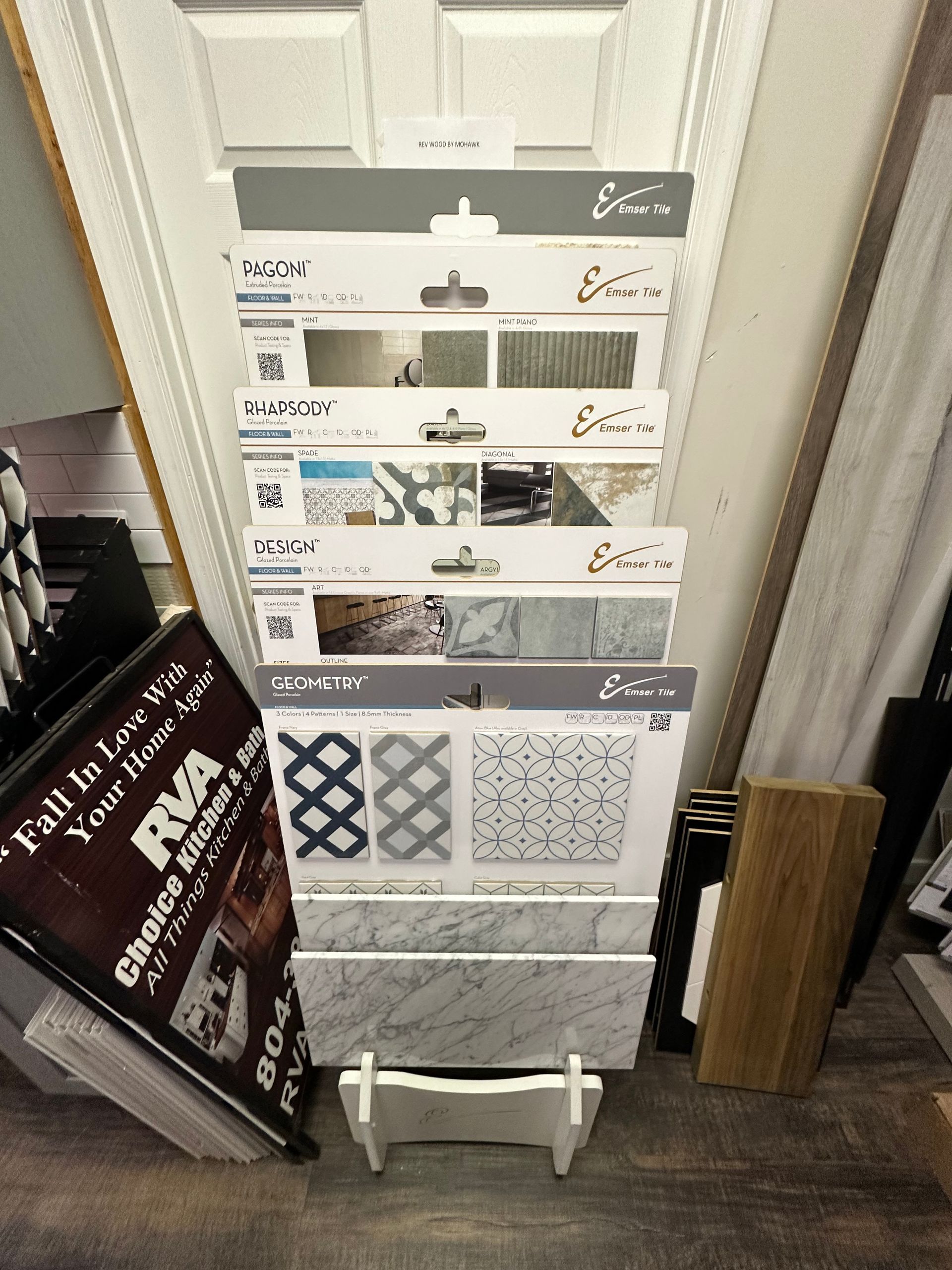 Display stand with tile samples. White holder displays various tile designs. RVA sign on the left.