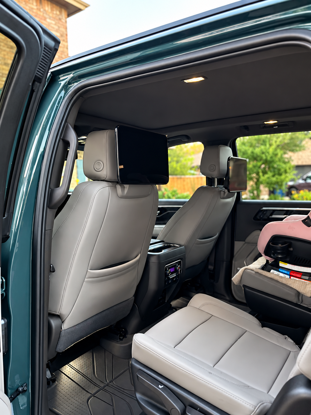 Open truck door showing black leather interior and dashboard under a bright blue sky