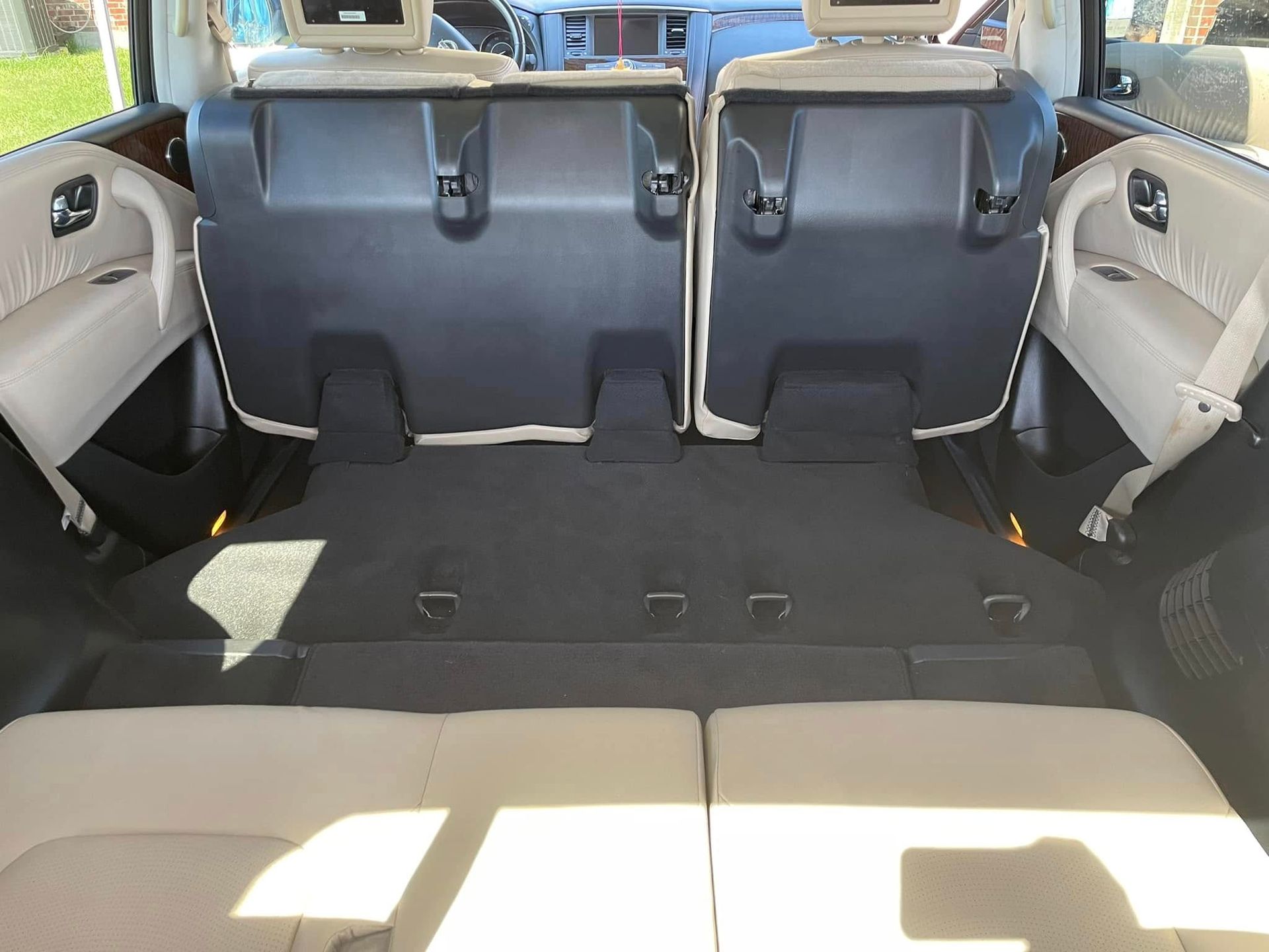 Open truck door showing black leather interior and dashboard under a bright blue sky