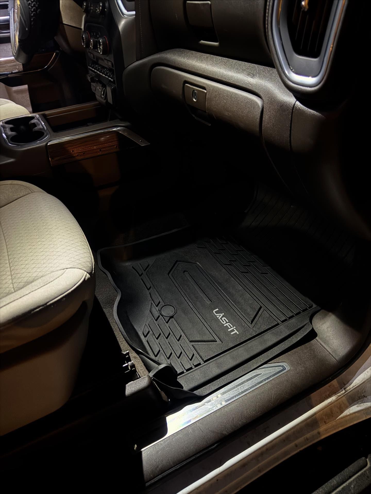 Car floor mat and beige seat in a vehicle interior, with wood trim and dark carpeting